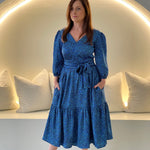 Sapphire background with a deep teal and black very discreet and discerning animal print. V-neck. Gathered sleeve at the shoulder. Roomy Sleeves that can be worn at long sleeves or three quarters. Cuffed at the wrist with discreet elastic threaded through. 7/8s in length. Two tier skirt. Lower tier with a subtle ruffle. Fitted at the waist with elastic threaded through the back discreetly for comfort and ease of getting on. Sash worn on waist. Centre back zipper.