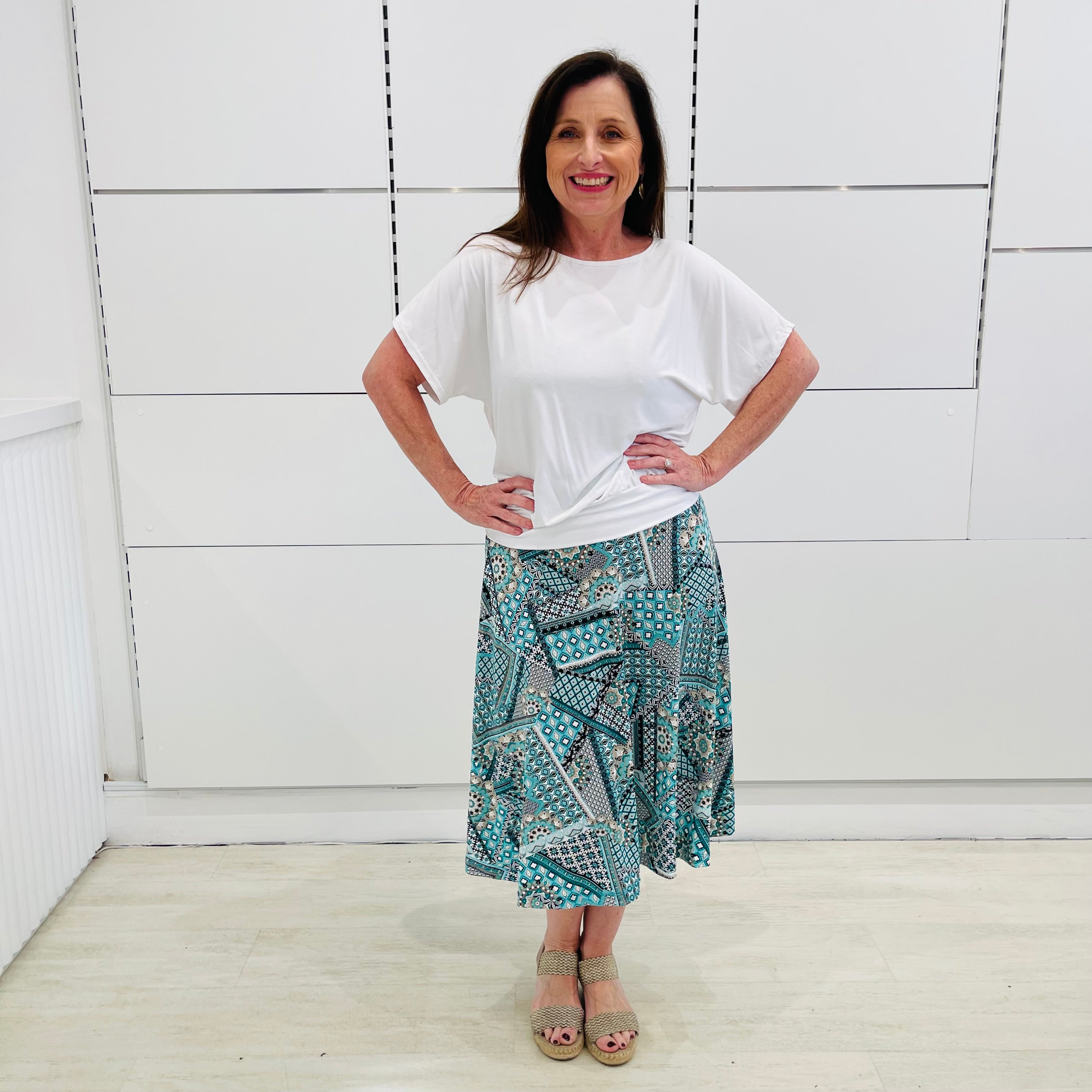 Green print, midi length, A line skirt, with stretch waistband. Worn with relaxed fit, loose line, scoop neckline, short sleeve, white bamboo top.