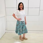 Green print, midi length, A line skirt, with stretch waistband. Worn with relaxed fit, loose line, scoop neckline, short sleeve, white bamboo top.