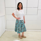 Green print, midi length, A line skirt, with stretch waistband. Worn with relaxed fit, loose line, scoop neckline, short sleeve, white bamboo top.