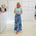 Woman wearing green short sleeve t shirt with long blue floral skirt.