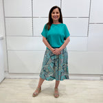 Green print, midi length, A line skirt, with stretch waistband. Worn with short sleeve, relaxed fit, green bamboo top.
