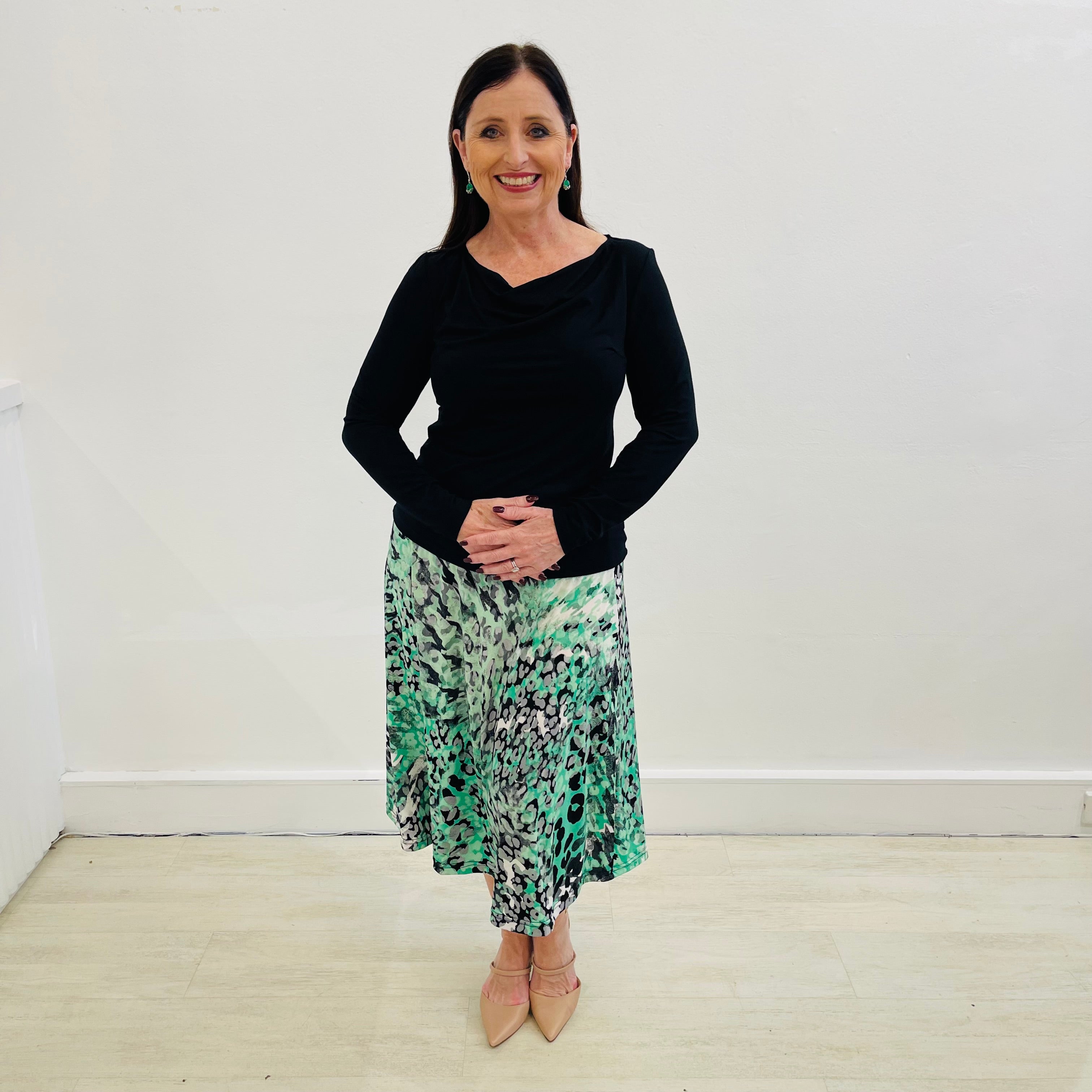 Green, black, white and silver geometrical/ animal print in a soft and flowy stretch jersey. Midi length aline skirt with flat stretch waist band threaded with discreet elastic for total comfort and style. Paired with a black bamboo blend cowl neckline top with long sleeves.