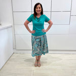 Green print, midi length, A line skirt, with stretch waistband. Worn with green bamboo, cowl neckline, short sleeve top.