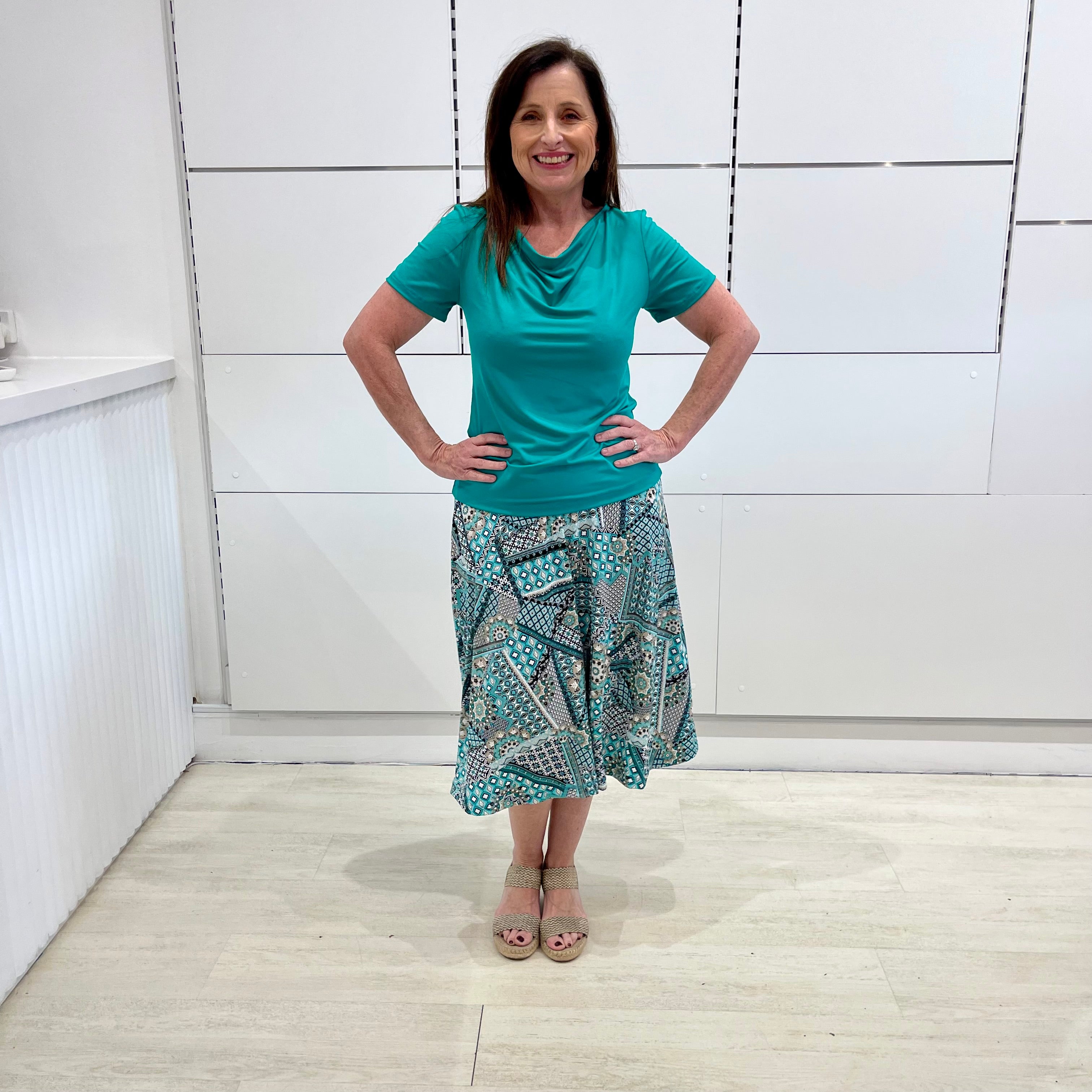 Green print, midi length, A line skirt, with stretch waistband. Worn with green bamboo, cowl neckline, short sleeve top.