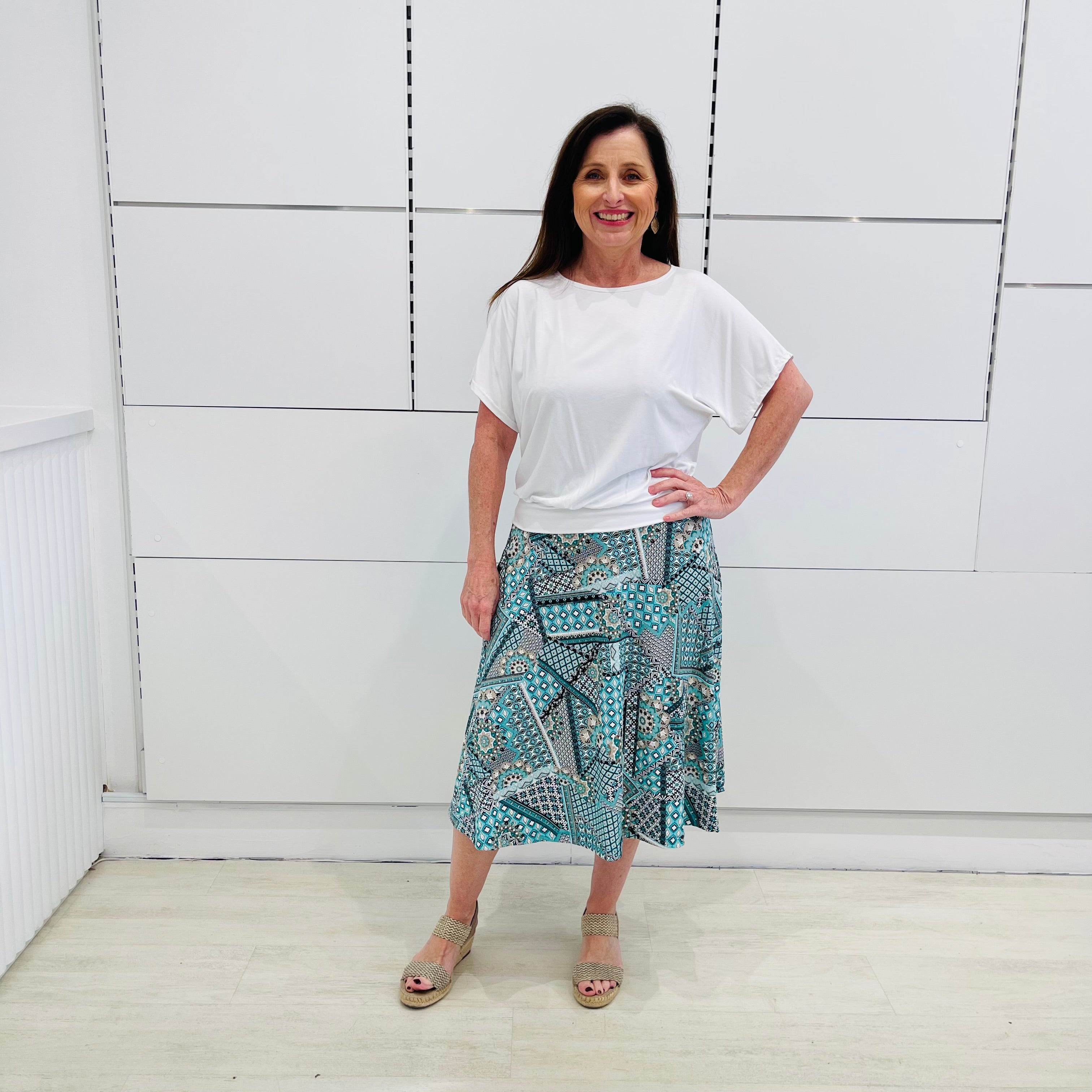 Green print, midi length, A line skirt, with stretch waistband. Worn with relaxed fit, loose line, scoop neckline, short sleeve, white bamboo top.