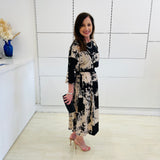 Black and beige print, 3/4 sleeve, midi length dress for special event wear. Relaxed fit dress. With black clutch bag.