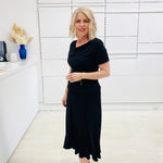 Woman wearing a black outfit in a white room