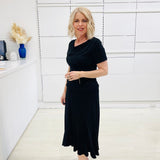 Woman wearing a black outfit in a white room