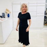 Woman wearing a black dress in a store setting