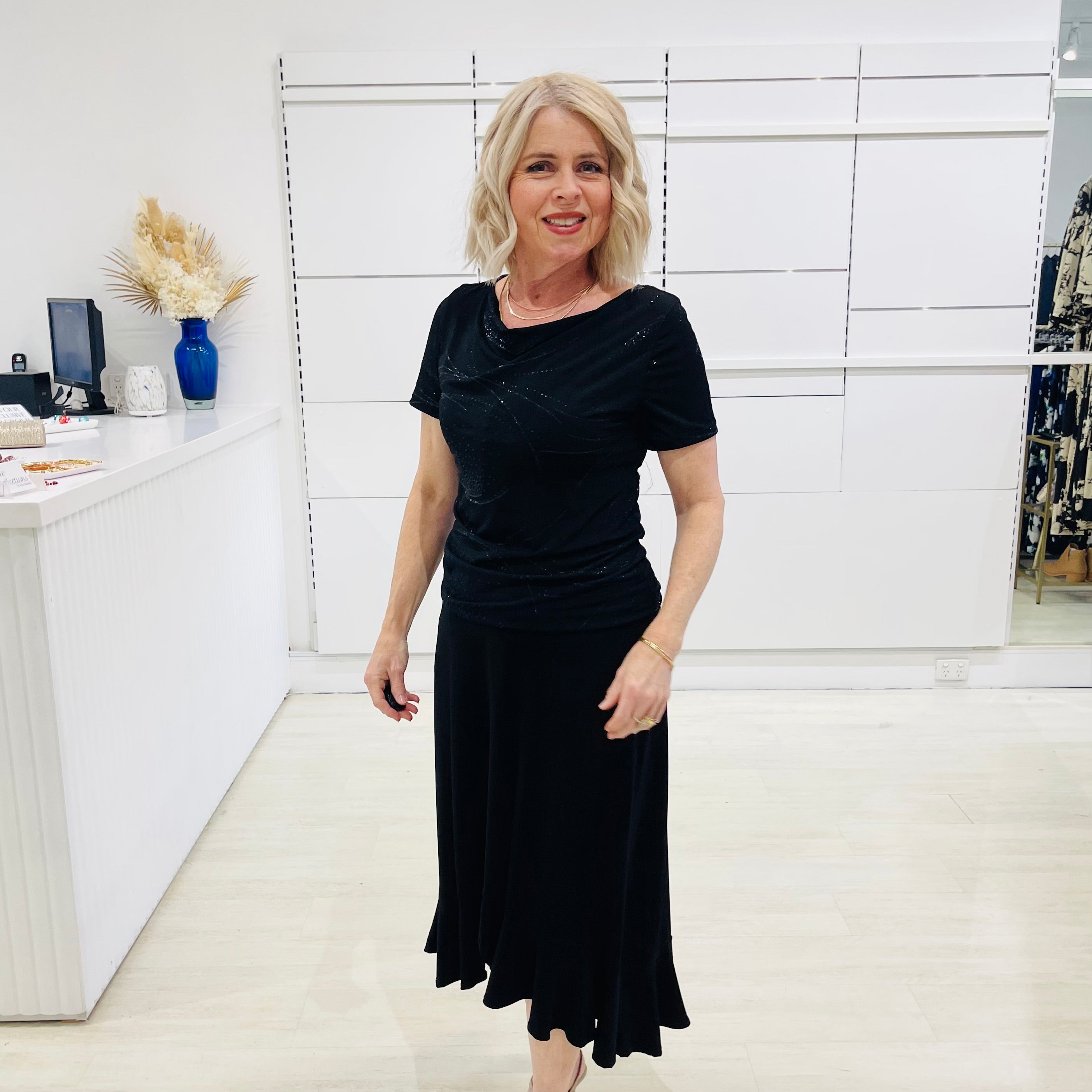 Woman wearing a black dress in a store setting