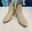 Intricate cut out design on cream colored man made leather ankle boots.