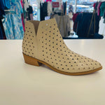 Intricate cut out design on cream colored man made leather ankle boots. Low 4cm heel. Zipper opening on side.