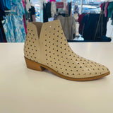 Intricate cut out design on cream colored man made leather ankle boots. Low 4cm heel. Zipper opening on side.