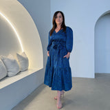 Sapphire background with a deep teal and black very discreet and discerning animal print. V-neck. Gathered sleeve at the shoulder. Roomy Sleeves that can be worn at long sleeves or three quarters. Cuffed at the wrist with discreet elastic threaded through. 7/8s in length. Two tier skirt. Lower tier with a subtle ruffle. Fitted at the waist with elastic threaded through the back discreetly for comfort and ease of getting on. Sash worn on waist. Centre back zipper.