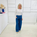 Denim blue,wide leg linen pants with flat waistband, zipper opening and pockets,worn with white bamboo, relaxed fit, long sleeve Gracie top.