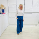 Denim blue,wide leg linen pants with flat waistband, zipper opening and pockets,worn with white bamboo, relaxed fit, long sleeve Gracie top.