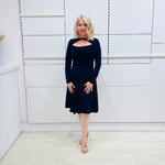 Penelope dress in deep navy blue, worn by model- elegant long sleeve design, knee length, with modern neckline.