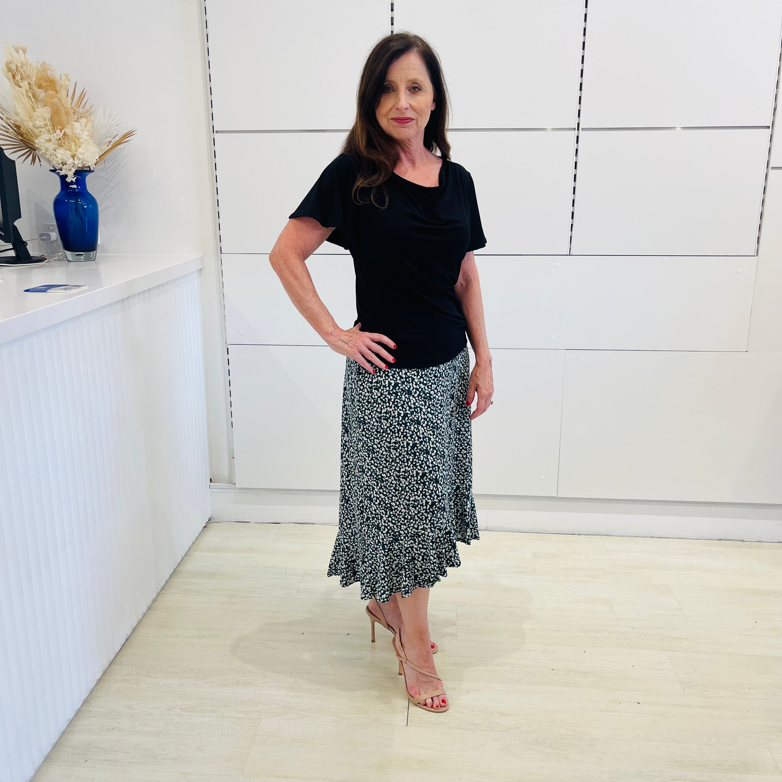 Green,black and white print, stretch, slight a-line skirt, with small ruffle on hemline. Worn with black, cowl neckline, short , wave sleeve top.