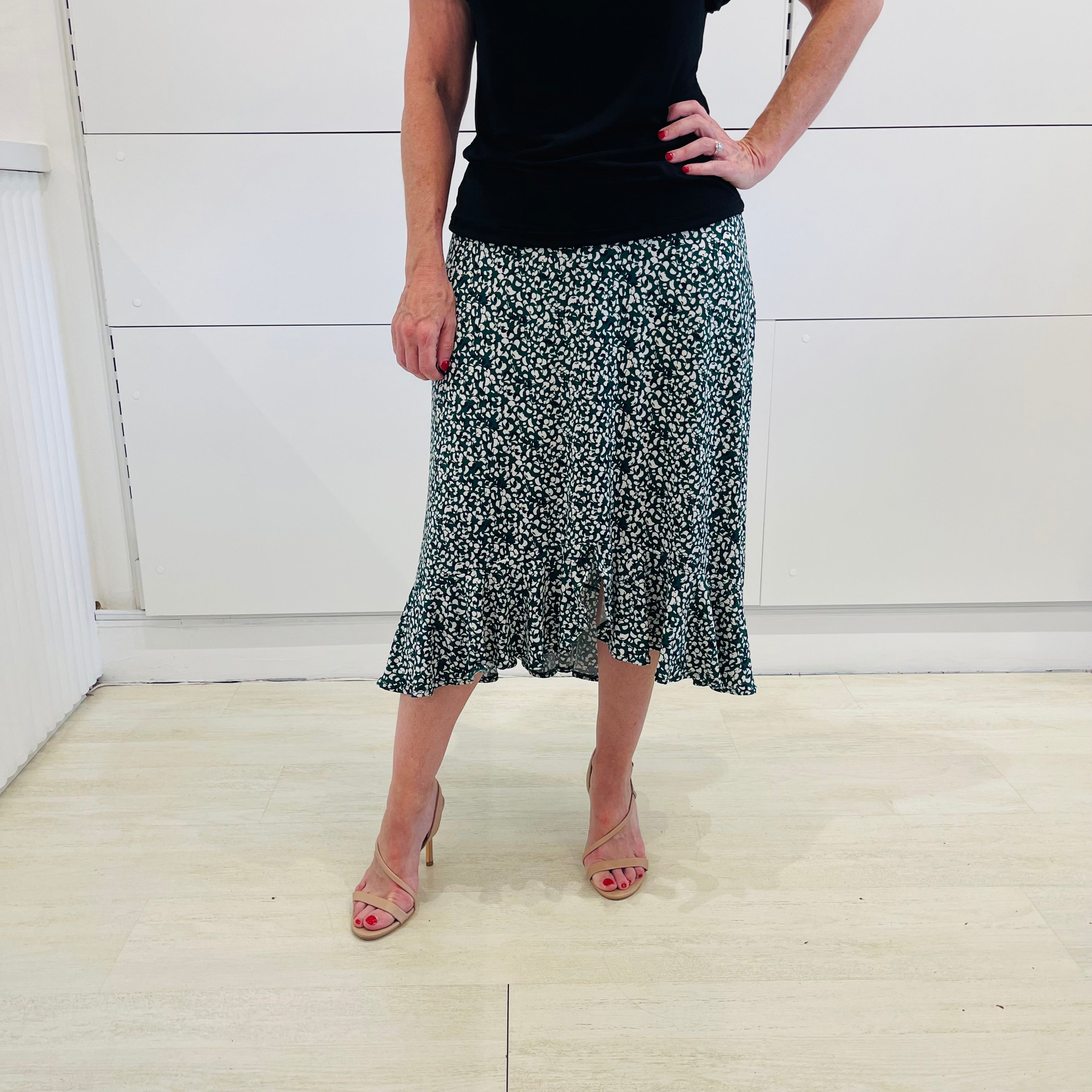 Green,black and white print, stretch, slight a-line skirt, with small ruffle on hemline. Worn with black bamboo, short sleeve top.