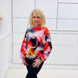 Woman wearing a colorful sweater against a white background