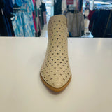 Intricate cut out design on cream colored man made leather ankle boots. Low 4cm heel. Zipper opening on side.