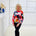Woman wearing a colorful sweater in a minimalistic room.