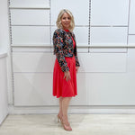Bright watermelon pink Penelope dress on model- vibrant colour, stretch dress, with feminine silhouette, long sleeve, a-line skirt and keyhole neckline. Worn with Selena Embroidered silk bolero Jacket.