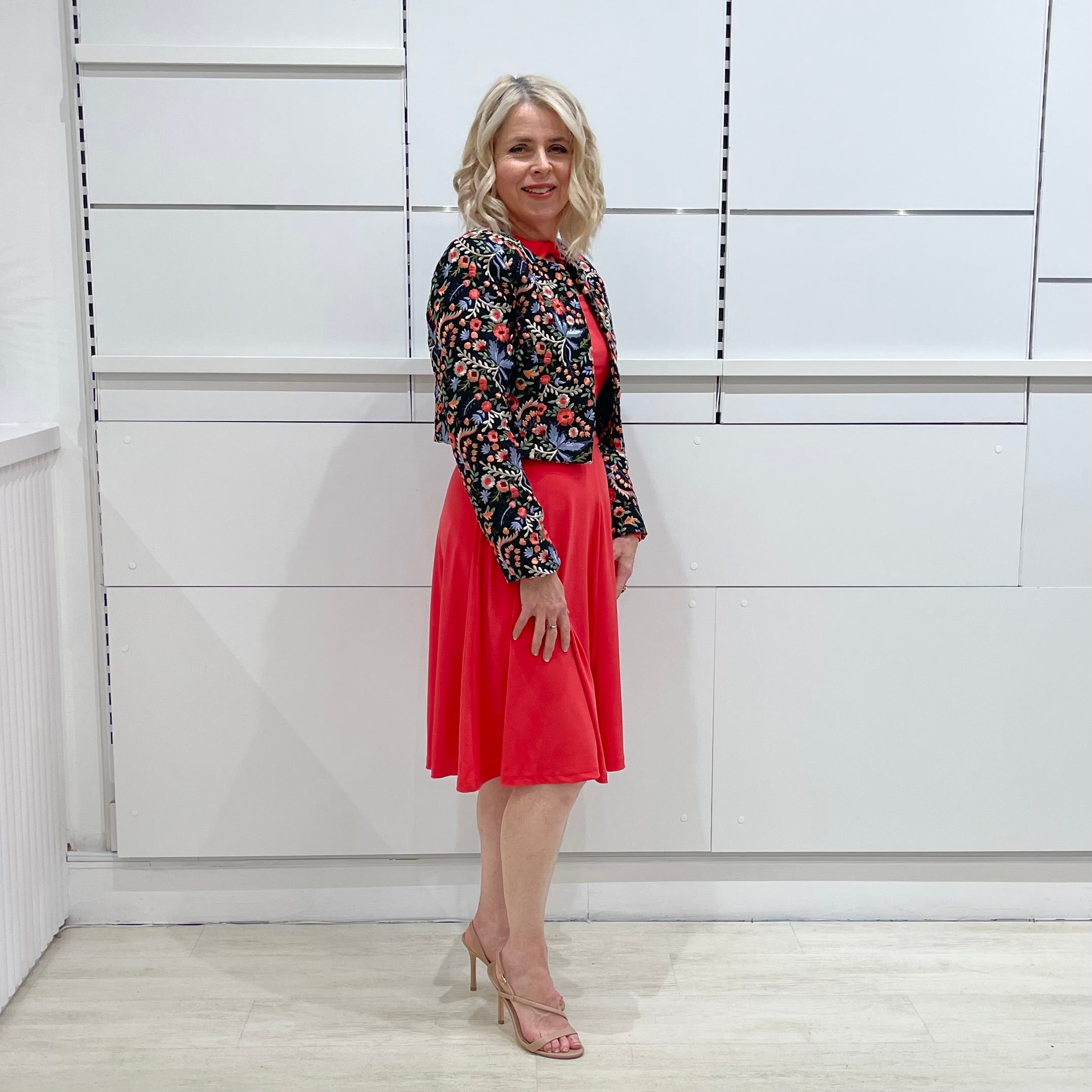 Bright watermelon pink Penelope dress on model- vibrant colour, stretch dress, with feminine silhouette, long sleeve, a-line skirt and keyhole neckline. Worn with Selena Embroidered silk bolero Jacket.