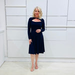 Penelope dress in deep navy blue, worn by model- elegant long sleeve design, knee length, with modern neckline.