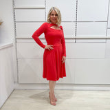 Bright watermelon pink Penelope dress on model- vibrant colour, stretch dress, with feminine silhouette, long sleeve, a-line skirt and keyhole neckline.
