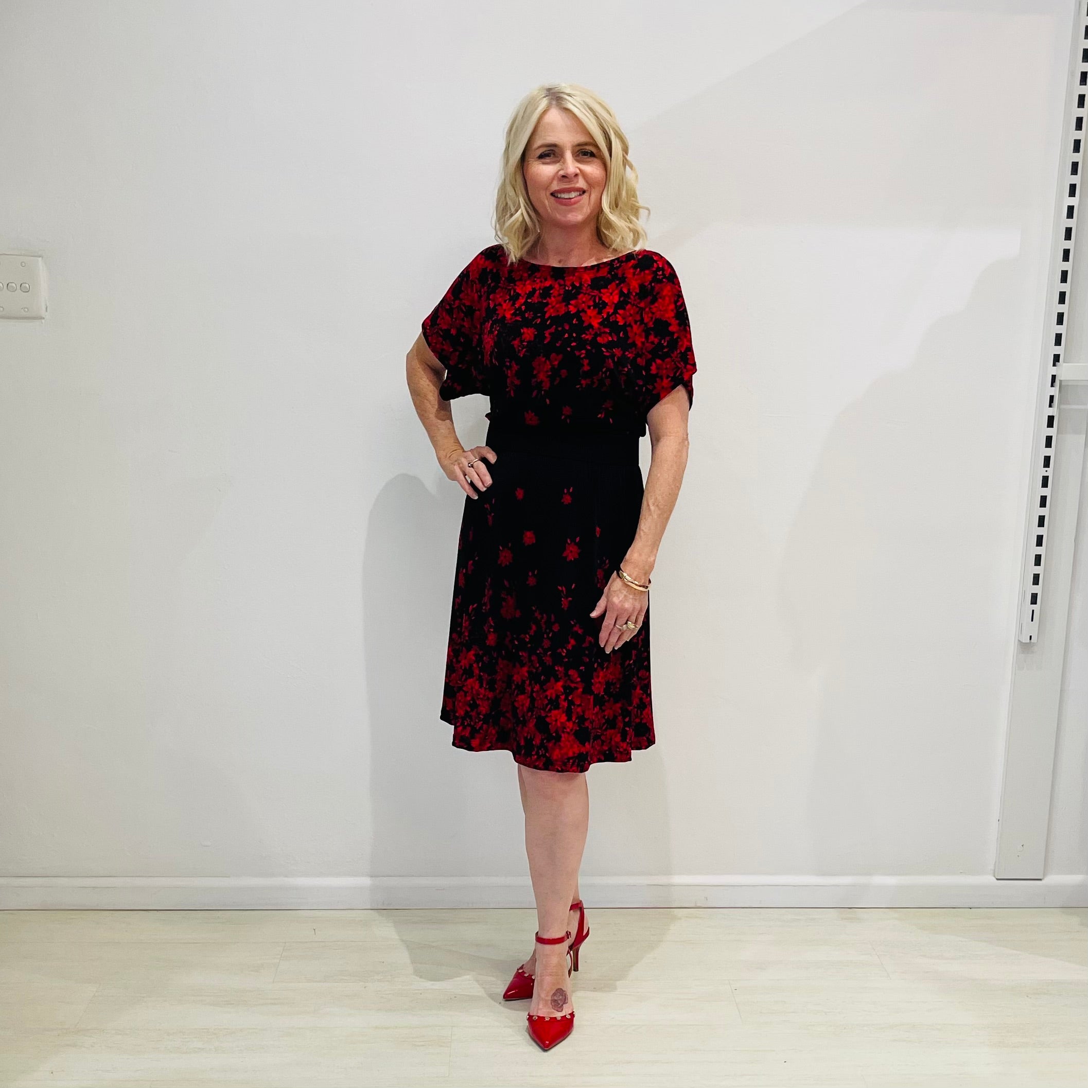 Black base colour dress with red floral border print on neckline and hemline. Short sleeve & knee length dress.