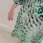 Green, black, white and silver geometrical/ animal print. Round neck. Gathered shoulder sleeve. Cuffed three-quarter sleeve. Stretch jersey. Super comfortable. Paired with an aline skirt of the same fabric. Midi length skirt with flat stretch waist band threaded with discreet elastic for total comfort and style.