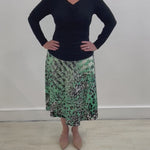 Green, black, white and silver geometrical/ animal print in a soft and flowy stretch jersey. Midi length aline skirt with flat stretch waist band threaded with discreet elastic for total comfort and style. Paired with a black bamboo blend cowl neckline top with long sleeves.