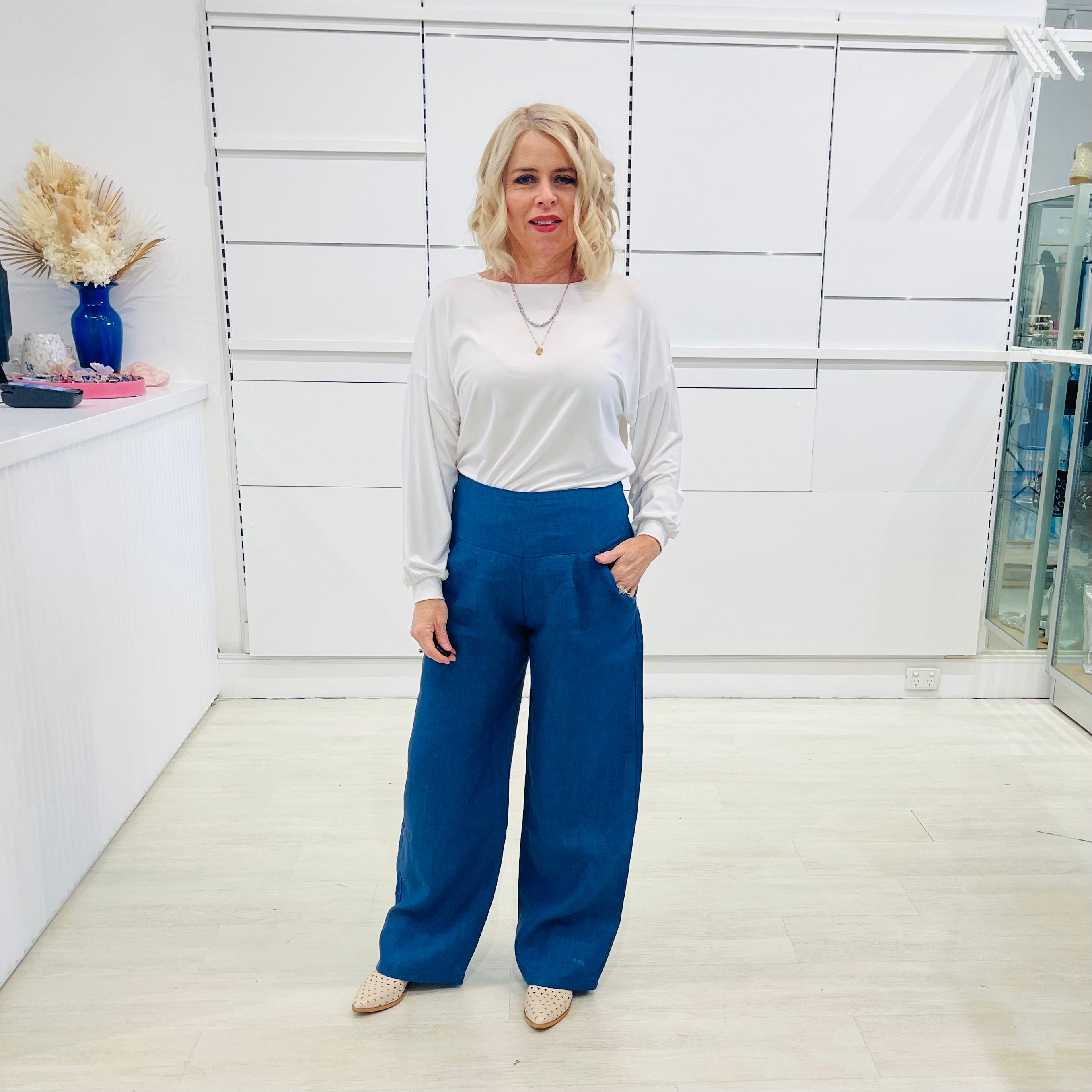 Denim blue,wide leg linen pants with flat waistband, zipper opening and pockets,worn with white bamboo, relaxed fit, long sleeve Gracie top.