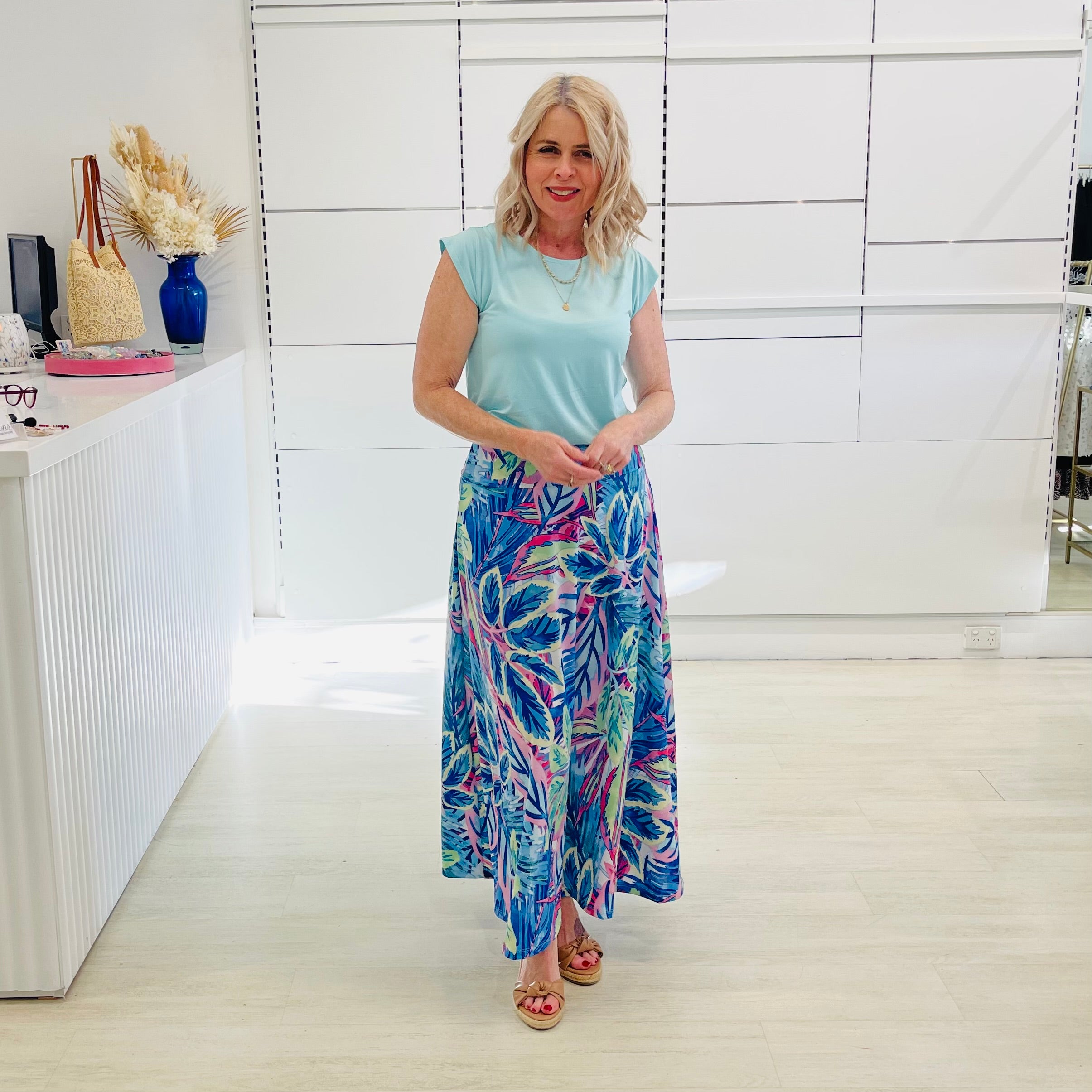 Woman wearing blue short sleeve t-shirt with maxi long blue floral skirt. 