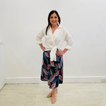 White Linen Long Sleeved Shirt with side tie detail at hemline. Autumn Radiance Aline Skirt with a leaf print in white, reds, teals, navy and black midi length skirt made in a stretch jersey flat discreet elastic through waistband.