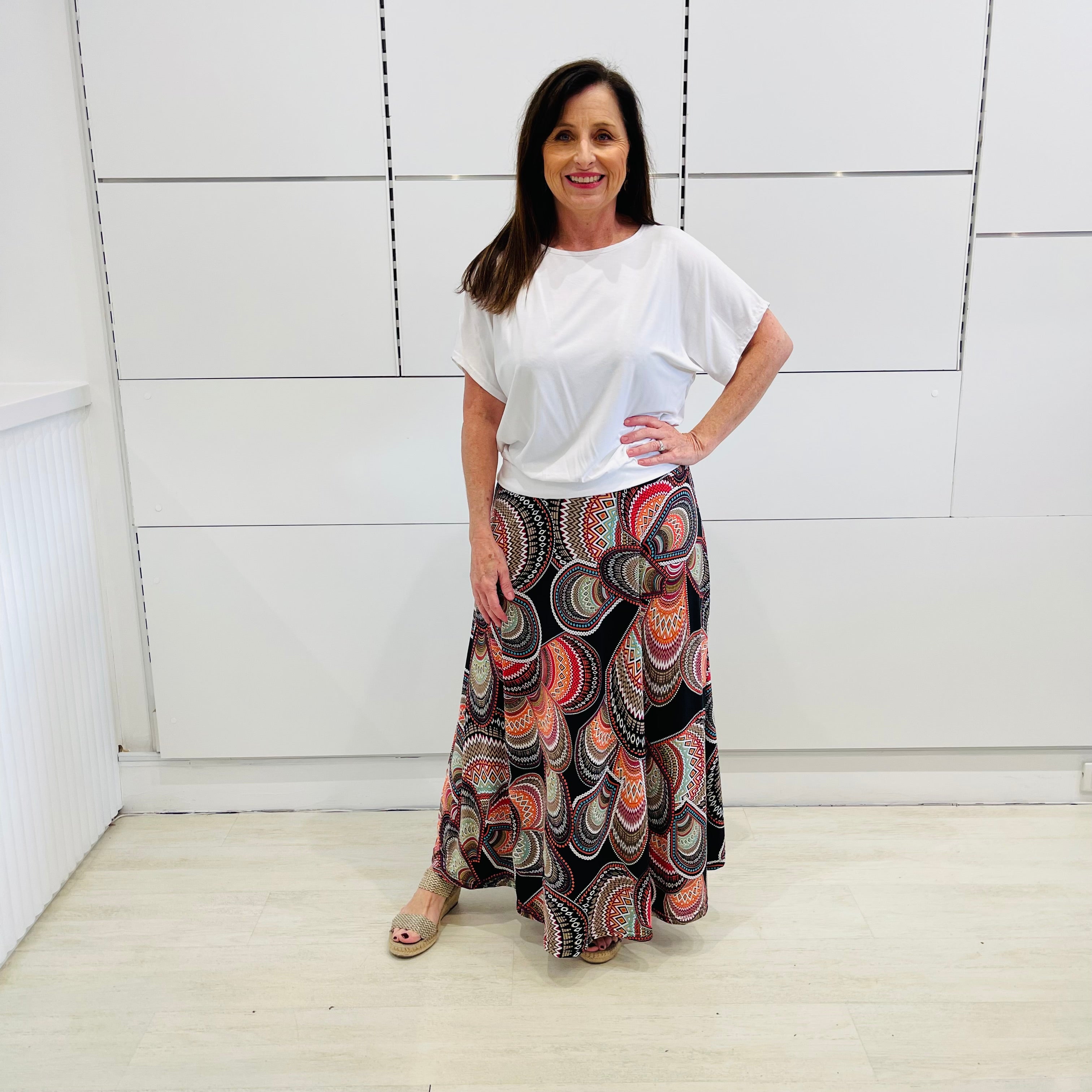 Long maxi skirt in aztec print of black,red, orange,worn with white bamboo, high round neck, short sleeve.