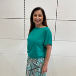 Emerald green bamboo, relaxed fit, scoop neckline , short sleeve, summer top, with band on hem for shape. Worn with long green patterned long, maxi skirt.
