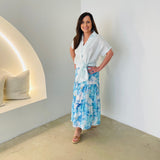 Women's pale blue linen shirt with side tie, worn with long, layered, blue floral , linen skirt