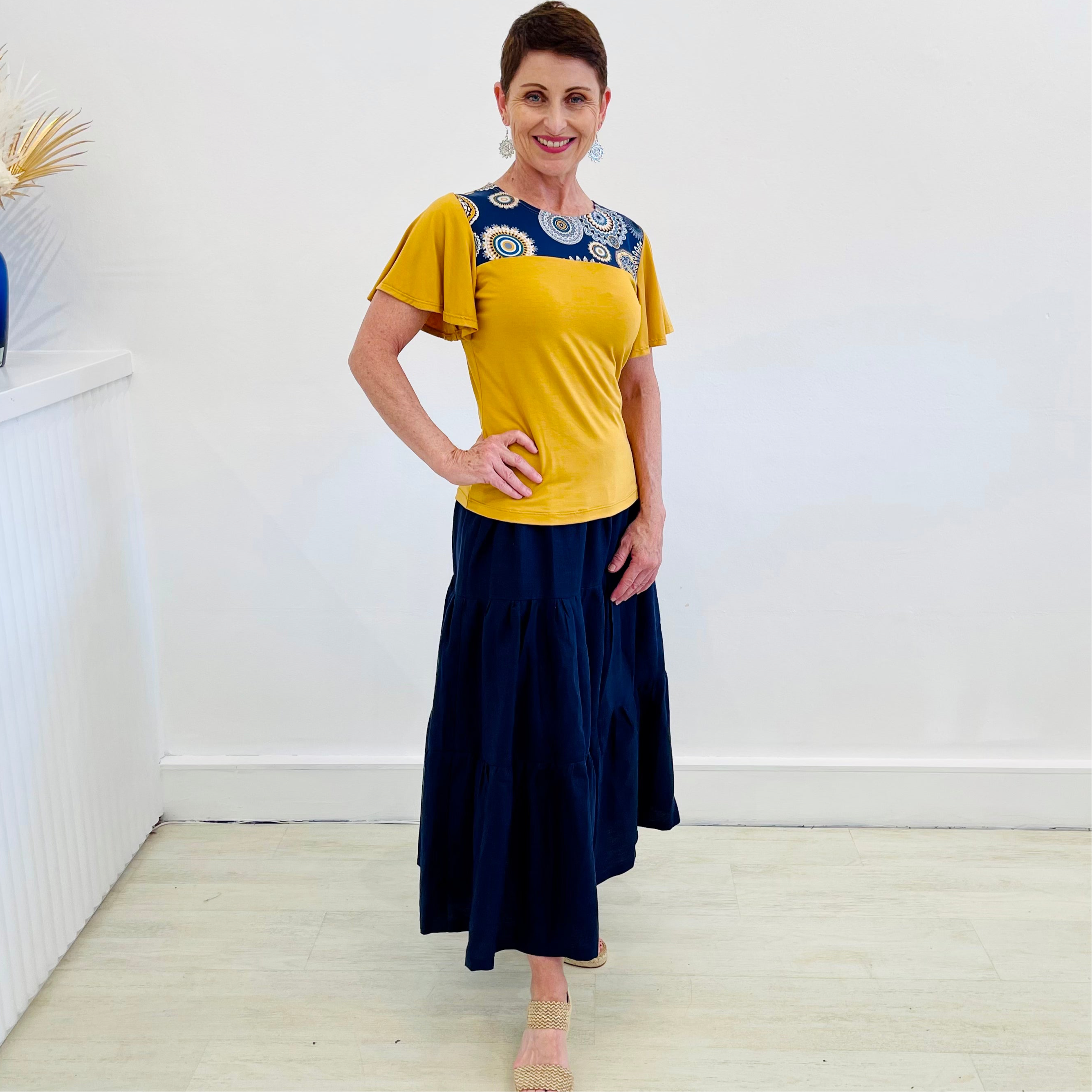 Navy Linen Tiered 7/8s length Skirt. Mustard yellow t-shirt with spirograph neck detail.