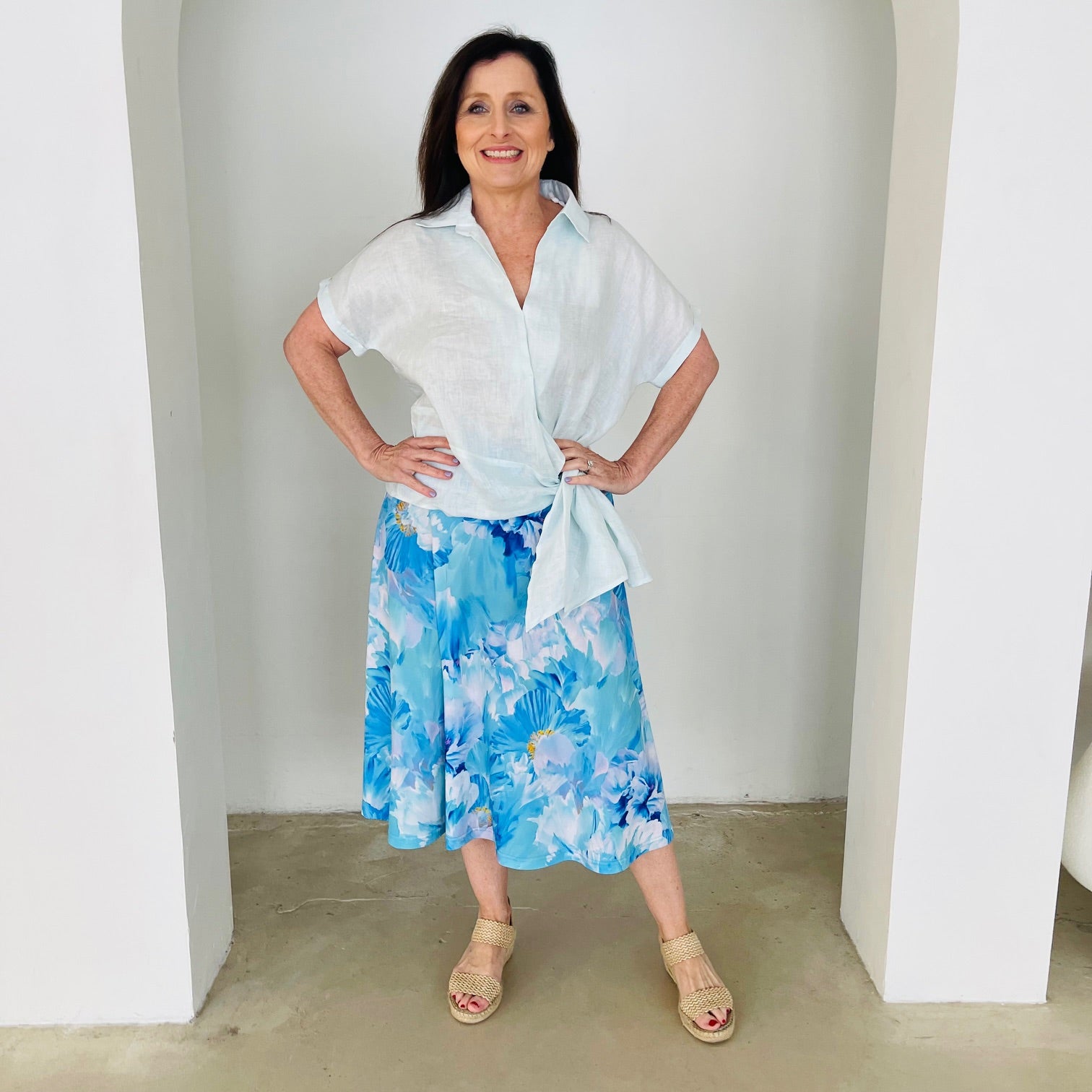 Women's pale blue linen shirt with side tie, worn with midi length, blue floral ,skirt