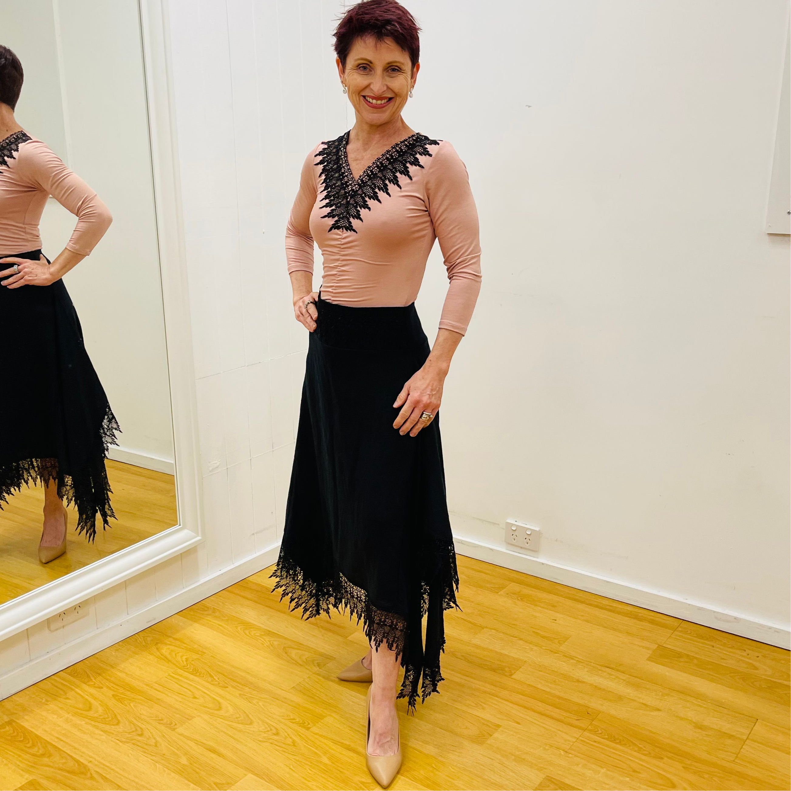 Black linen skirt, with lace detail on waistband and around the handkerchief, uneven, hemline. With pale pink, black lace v neckline detail top.