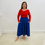 Royal blue,full circle skirt, with dipped hemline at back, wide flat waistband, with zipper opening and side seam pockets. Red bamboo, cowl neckline, long sleeve, semi fitted women's top.