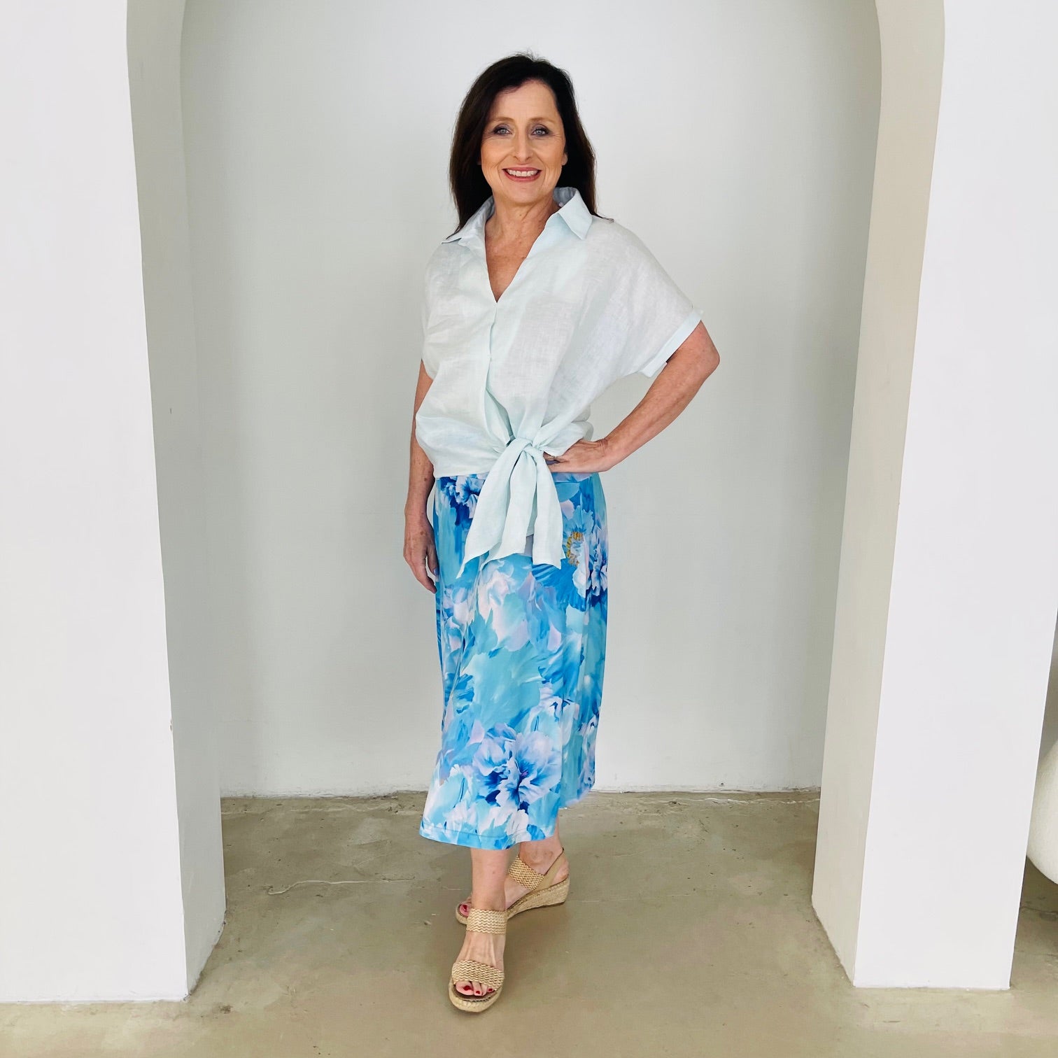 Women's pale blue linen shirt with side tie, worn with midi length, blue floral ,skirt