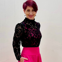 bLACK lACE TOP WITH LONG SLEEVES AND HIGH NECKLINE, PINK CAMISOLE WORN UNDER BLACK LACE TOP, AND PINK SKIRT