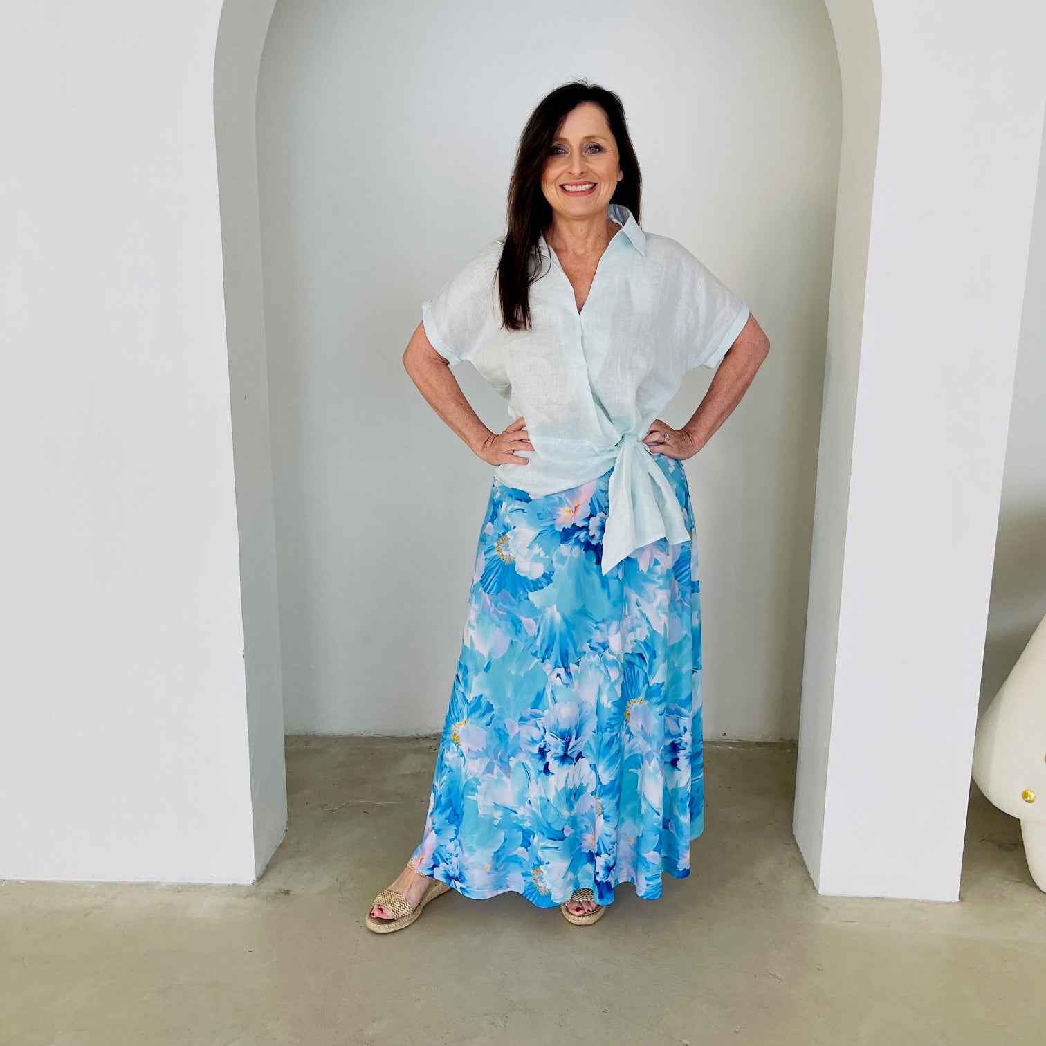 Women's pale blue linen shirt with side tie, worn with long, maxi,  length, blue floral ,skirt