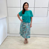 Emerald green bamboo, relaxed fit, scoop neckline , short sleeve, summer top, with band on hem for shape. Worn with long green patterned midi skirt.