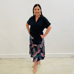 Black Linen Short Sleeved Shirt with side tie detail at hemline. Autumn Radiance Aline Skirt with a leaf print in white, reds, teals, navy and black midi length skirt made in a stretch jersey flat discreet elastic through waistband.