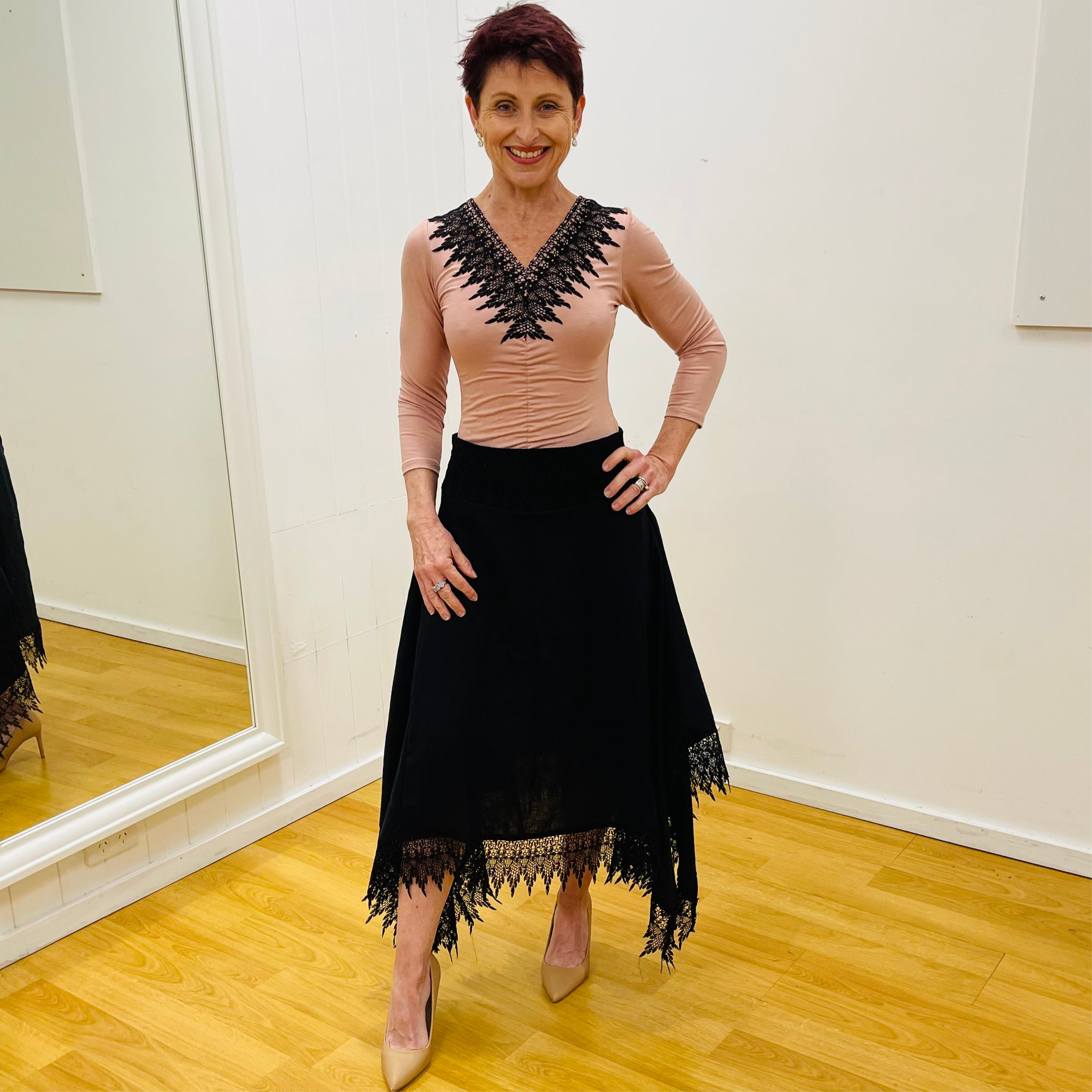 Black linen skirt, with lace detail on waistband and around the handkerchief, uneven, hemline. With pale pink, black lace v neckline detail top.